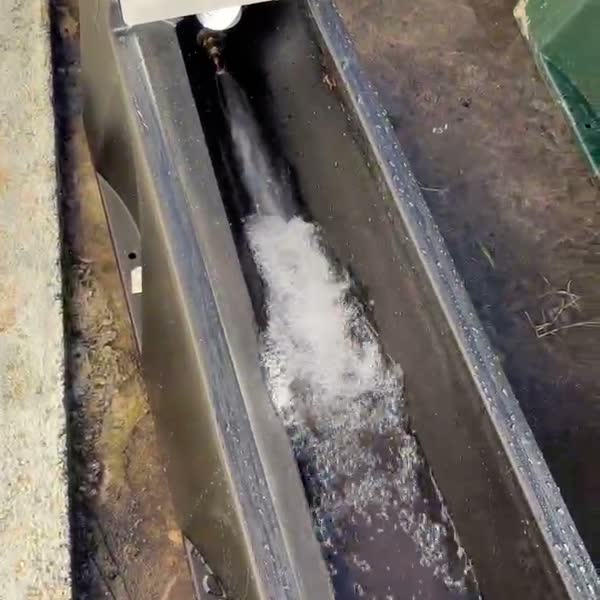 A surge of water running along the trough